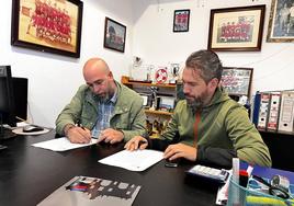 El presidente del club guareñense, José Ángel Flores (i), firma la recepción del desfibrilador que le entregó el delegado de deportes, Pedro Gil.