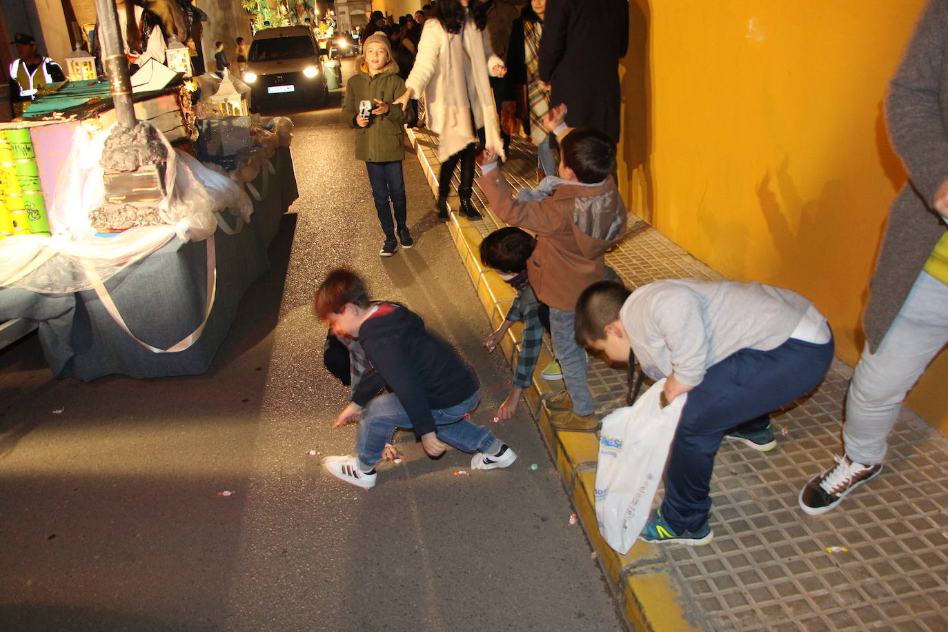 Muchos niños recogiendo caramelos del suelo.