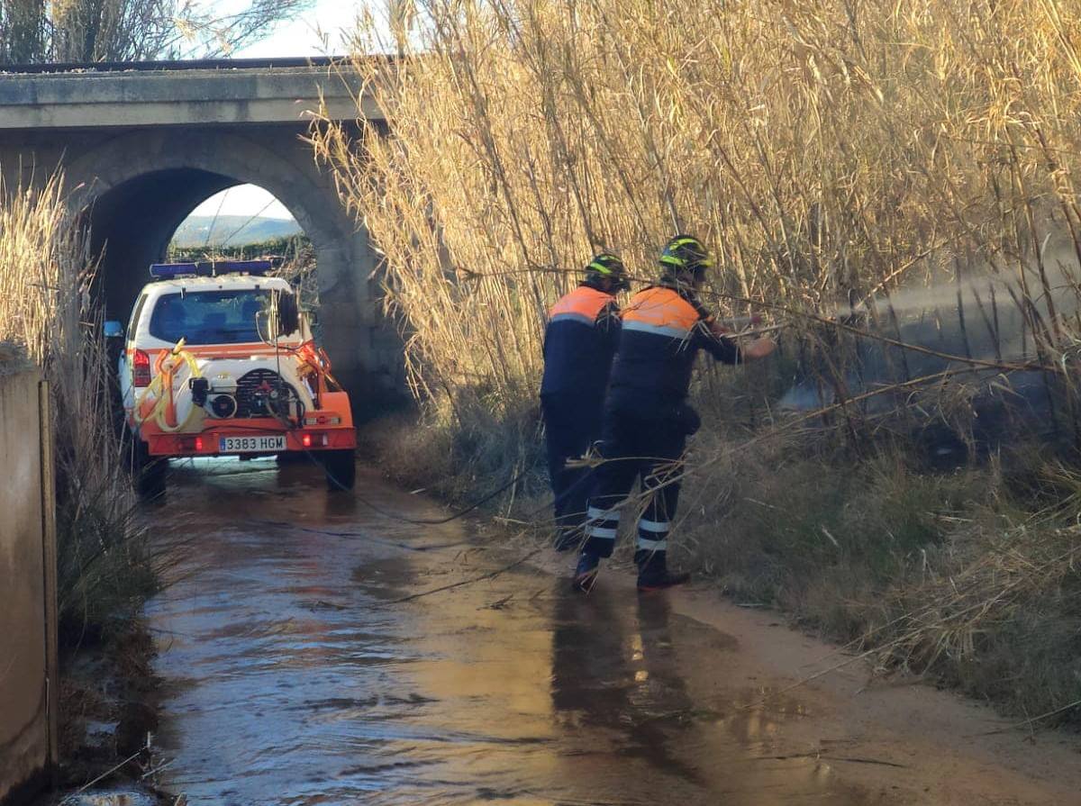 Imagen de una actuación de bomberos voluntarios de Protección Civil sofocando un incendio en un cañal en la Alcantarilla de la Estación.