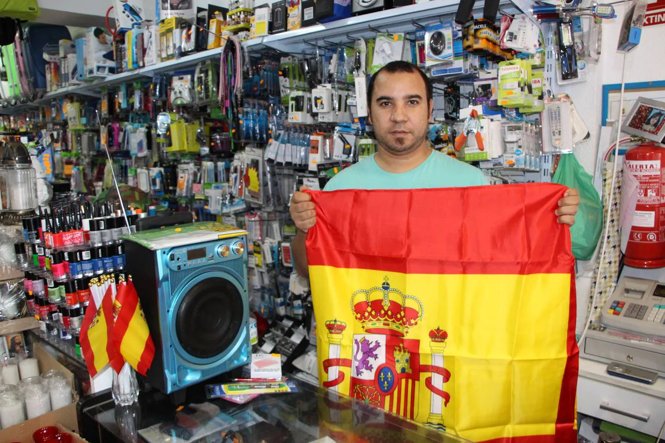 Mustafá en su tienda de la calle Pajares mostrando la bandera constitucional de España.