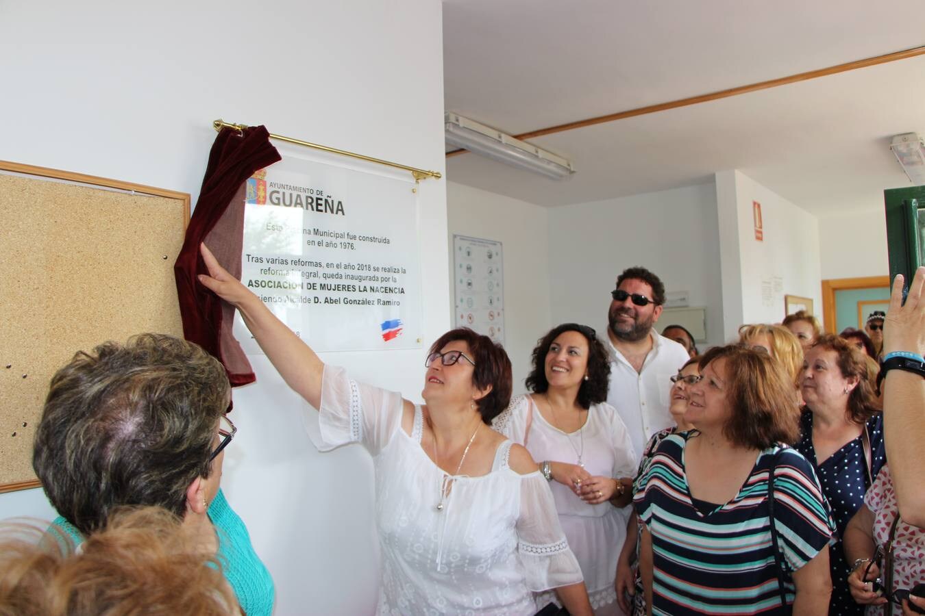 La presidenta de la asociación de mujeres, Remedios Merino, descubre la placa, inaugurándose la reforma y el inicio de la campaña de verano 2018 en la piscina municipal.
