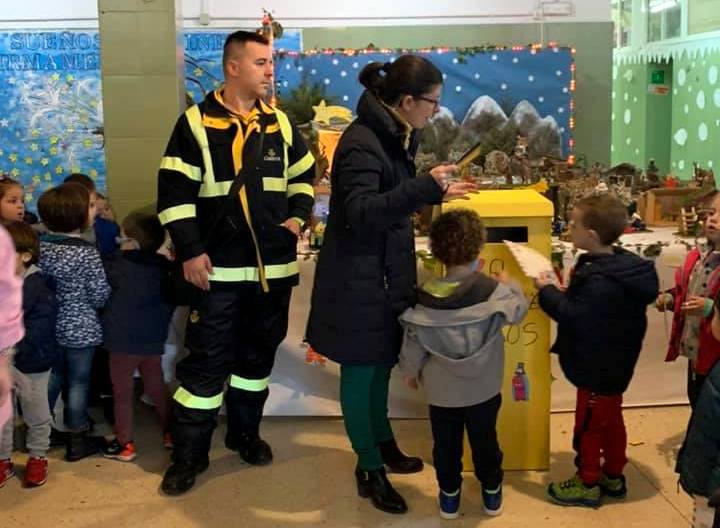Los escolares depositan las cartas en el buzón.
