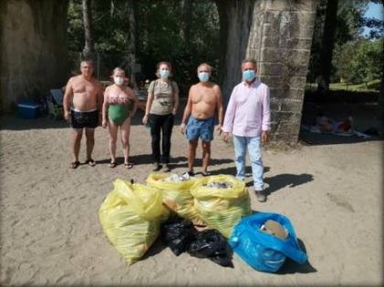 Los bañistas y monitores muestran la basura recogida. 