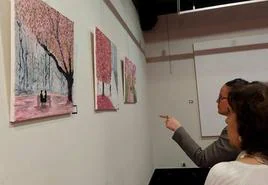 Dos mujeres viendo la exposición de pintura en el museo.