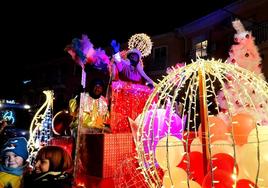 Baltasar y sus pajes saludan a la multitud desde su nueva carroza.