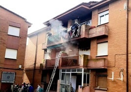 Evacuación de los vecinos en la parte de atrás y piso siniestrado en la parte derecha con las ventanas cerradas.