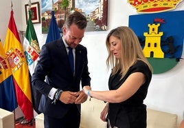 Luis Miguel Núñez colocando la pulsera a María Guardiola.