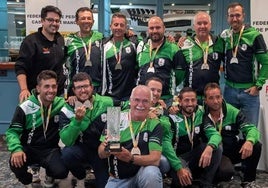 Carlos Labrador, de pie, el primero por la derecha, con el resto del equipo mostrando las medallas y trofeo.