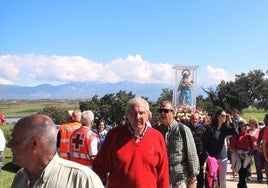 Los devotos portando a hombros la imagen de la Patrona cerca de la ermita de la dehesa.