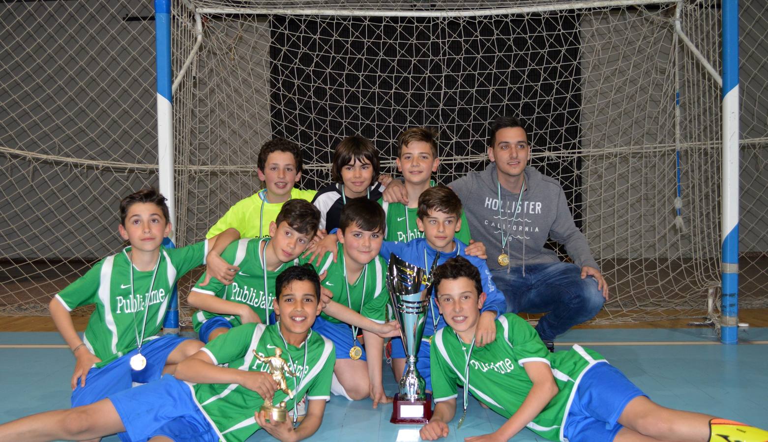 Jugadores y entrenador con los trofeos.