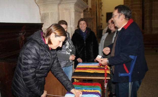 Miembros de la Cofradía de Nuestro Padre Jesús vendiendo los cordones de San Blas en Santa María.