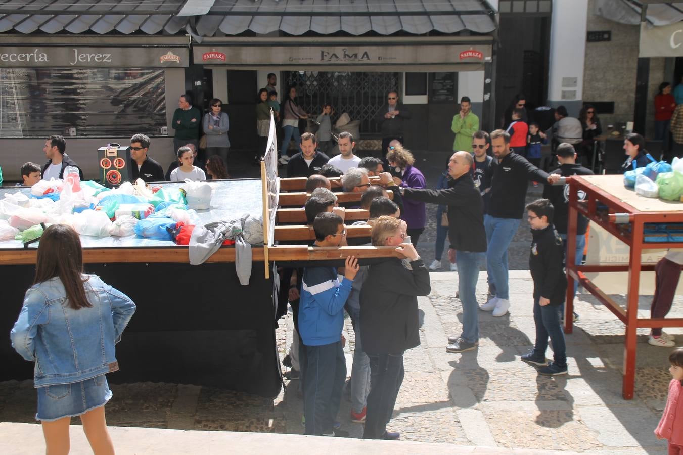 Costaleros y costaleras de la Semana Santa de Jerez de los Caballeros, Fiesta de Interés Turístico Nacional, han vivido este domingo una gran jornada de unión y convivencia y han recorrido las calles de la ciudad portando la solidaridad de numerosos vecinos y vecinas que han respondido a su llamamiento, '¡Échame kilos¡', aportando alimentos no perecederos con destino al almacén de alimentos que gestiona la Asamblea Local de Cruz Roja.Unos 200 costaleros y costaleras de las distintas Cofradías y Hermandades jerezanas, han participado en esta cita, por primera vez bajo la organización de la Asociación que les agrupa y junto con la Junta de Cofradías, disfrutando finalmente de un bonito encuentro en la Casa de la Iglesia