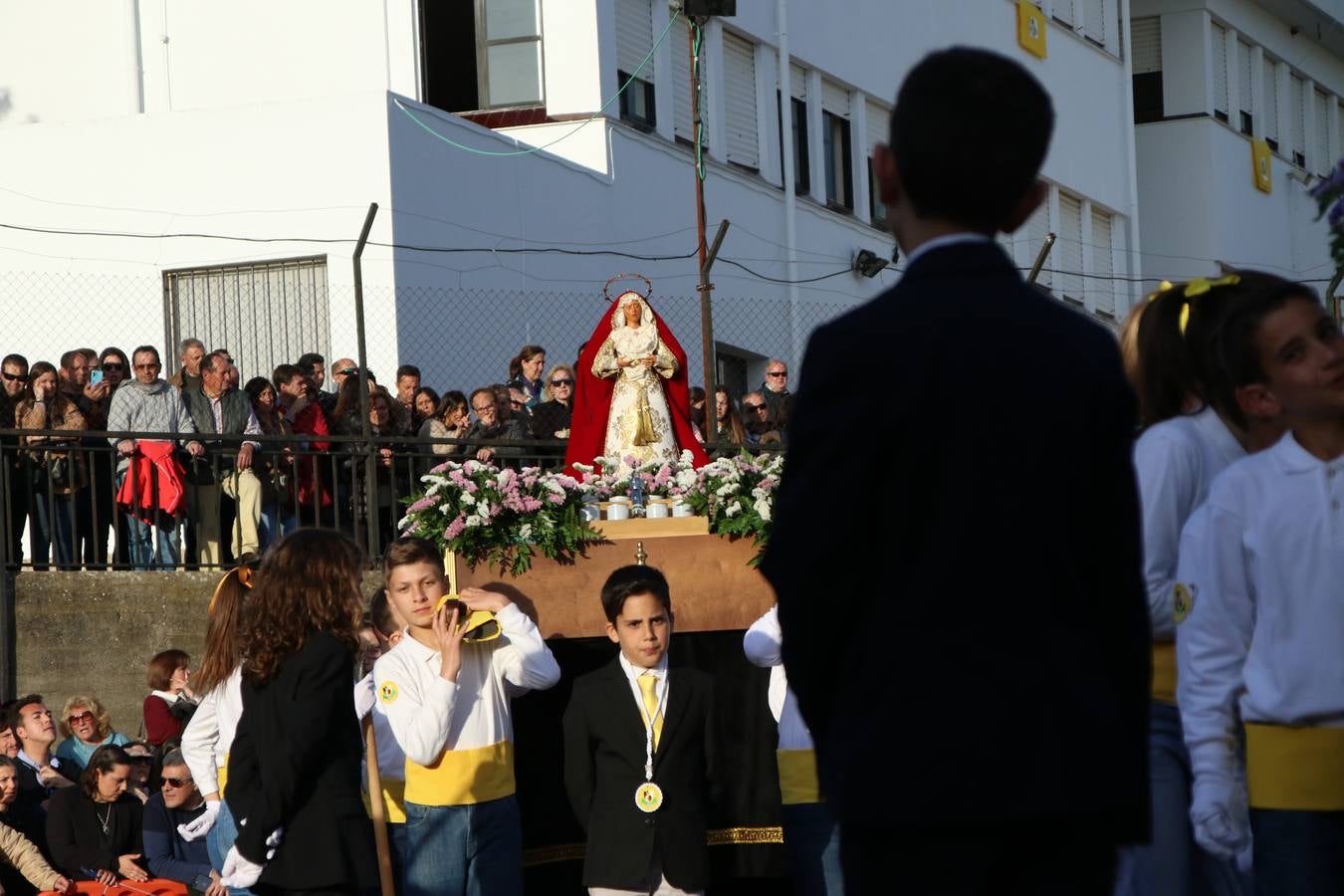 El Colegio «El Rodeo» celebró, ayer, una nueva edición de su Semana Santa infantil que, año tras año, se consolida como una de las citas imprescindibles del calendario cofrade jerezano. La iniciativa cuenta con la implicación de alumnos, padres y profesores, y muestra cómo los más pequeños comienzan a interiorizar los roles propios de quienes participan y hacen posible la Semana Santa del municipio: costaleros, capataces, nazarenos, agrupaciones musicales, mujeres ataviadas con mantilla negra, escoltas romanas, etc. La Agrupación Musical «Nuestro Padre Jesús Nazareno» y la Agrupación Musical «Maestro Sousa» de la OJE acompañaron con sus sones esta entrañable recreación.