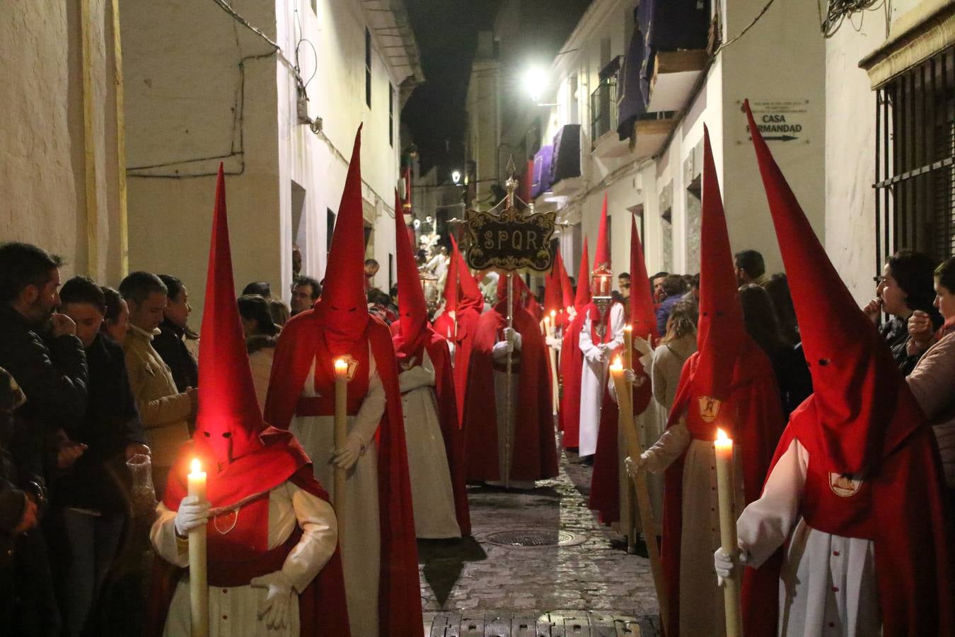 La vista al cielo se convertía, ayer, en una de las prácticas más repetida por los jerezanos. La lluvia amenazaba con marcar un antes y después en la Semana Santa jerezana 2019, Fiesta de Interés Turístico Nacional, e impedir la salida de la Cofradía del Señor 'Ecce-Homo', protagonista del Miércoles Santo. Una leve llovizna que, comenzaría a principio de la tarde, se convirtió en persistente a medida que pasaban las horas. Razón por la que la Cofradía decidió retrasar su hora de salida hasta pasadas las 21:30 horas, cuando la puerta del Perdón de San Miguel Arcángel se abría para iniciar el desfile procesional. Un desfile procesional que se vio interrumpido, de nuevo, por la lluvia, obligando al Señor 'Ecce-Homo' y Nuestra Señora de los Desamparados a regresar al templo. 