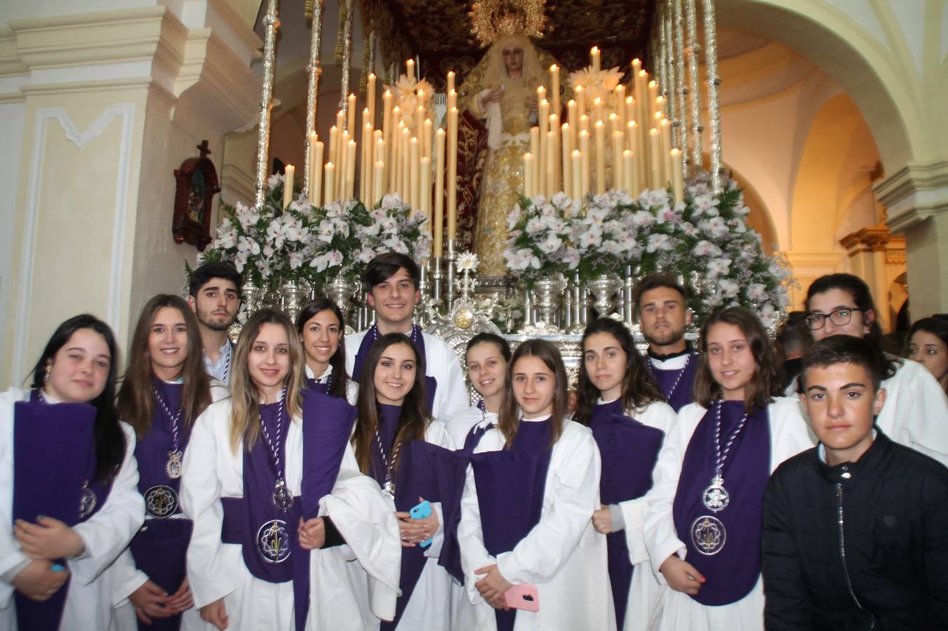 Las emociones llenaron también anoche la ermita de Los Santos Mártires, donde se quedaron guardados todos los afanes, las ilusiones y la devoción que no pudieron tener reflejo en la procesión de las colas largas, La Cofradía del Señor Coronado de Espinas decidió no salir ante la adversidad de la climatología y en el interior de este pequeño templo se vivieron momentos de gran emotividad.La Guardia Civil de Jerez de los Caballeros rindió honores a s Madrina, María Santísima de la Amargura. Los sones de las bandas y agrupaciones que iban a participar en el desfile procesional expandieron su eco desde el Llano de los Mártires para acompañar a los costaleros de cada uno de los tres Pasos, que fueron mecidos a su compás. El jovencísimo saetero Julián Jaramillo, de tan solo 12 años y natural de Segura de León, hizo vibrar a los presentes con su saeta al Coronado.Y entre las oraciones del párroco, Antonio María Rejano y los sacerdotes que le acompañaron, asomaron también las lágrimas.El momento más emotivo se vivió con el sentido homenaje a Manuel Labrador González, Manolo 'Cornelio' a quien Marisa Sánchez, en nombre de la junta de gobierno de la Cofradía del Señor Coronado, dedicó palabras llenas de afecto y reconocimiento, destacando su condición de «trabajador sin igual», su carácter innovador, su generosidad, sus consejos a jóvenes y mayores en el seno de esta Cofradía de la que dijo, «es piedra angular» y su extraordinaria labor. Manuel recibió un libro y una precioso cartel realizada por José Tomás Pérez Indiano, a semejanza del que hace tres años anunció la Semana Santa Jerezana. Emocionado, Manuel agradeció el cariño y dedicó este homenaje a su familia y a todas las madres.