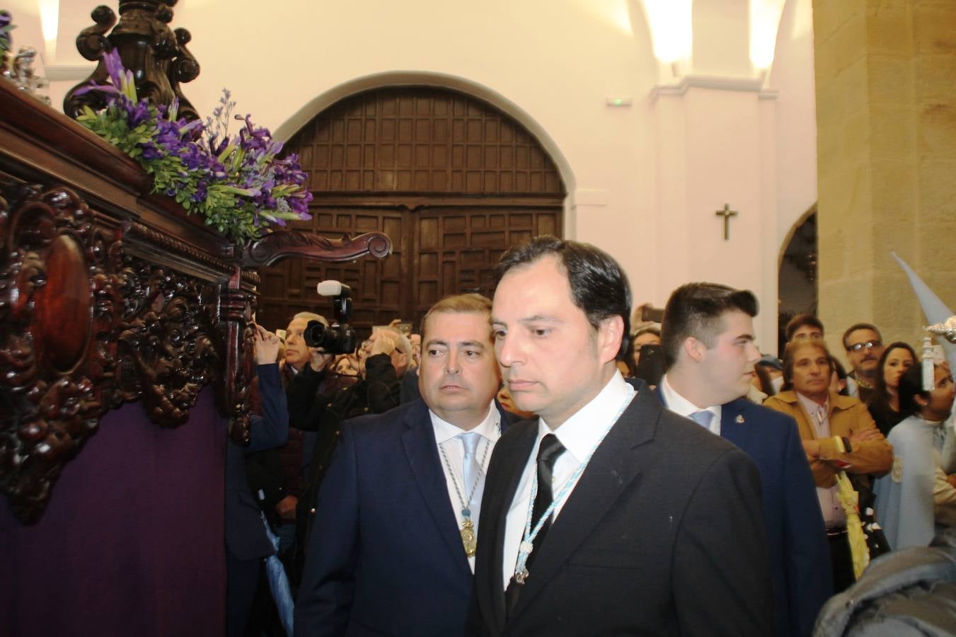 La lluvia que durante las primeras horas de la tarde se contuvo, hizo acto de presencia nada más asomarse a la calle la procesión de las túnicas celestes, que organiza la Archicofrafía del Santísimo Sacramento. Todas las emociones se vieron frustradas y el templo de San Bartolomé fue refugio para el sentimiento de quienes anhelaban acompañar esta estación de penitencia en la que se representa el momento de la institución de la Santa Cena, que junto al de Jesús ante Pilatos, fueron los únicos que realizaron su salida de la iglesia patronal. El Cristo de la Piedad, imagen impresionante en el itinerario de la Semana Santa jerezana, y la hermosa Virgen de la Paza, se quedaron dentro.Los sones de las Agruaciones y bandas que iban a acompañar este desfile sonaron especiales para bailar estas dos imágenes y servir de consuelo, mientras brotaban lágrimas en los ojos de algunos niños que encuentran en esta Cofradía su bautismo nazareno. La oración también acompañó estos momentos de tristeza al tiempo tan especiales.