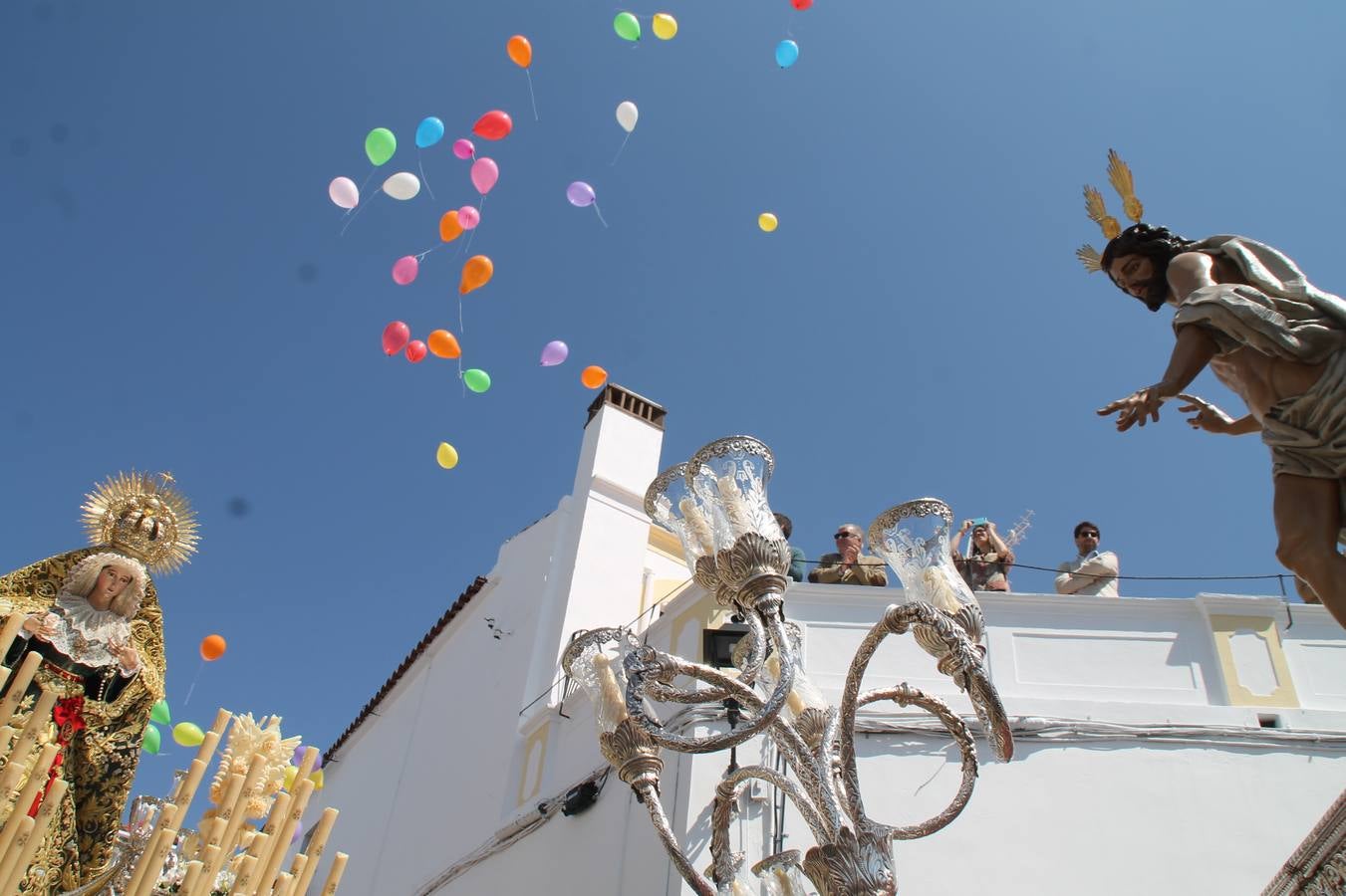 La luz y el gozo han puesto un gran broche a una Semana Santa, aciaga en sus momentos más intensos, a causa del mal tiempo que desde la noche del Miércoles y hasta el Viernes Santo trastocó en buena medida su desarrollo.Hoy el sol ha lucido en el cielo que como, cada Domingo de Resurrección, ha servido de Palio al hermoso Paso de la Virgen del Rosario, haciendo resplandecer, al tiempo, el momento culmen de esta celebración, el reencuentro en la Madre y el Hijo en la Fuente de los Santos, abarrotada de público. El momento ha sido emocionante, con los costaleros de la virgen y del Paso del Resucitado subiendo los brazos al cielo para representar el abrazo de ambas imágenes, ante la tradicional suelta de globos de ecolores y el estrépito de cornetas y tambores.La procesión ha seguido su curso hacia la Plaza de España, también muy concurrida, siendo en este escenario donde, miembros de Grupo Joven de la Cofradía del Coronado han regalado una petalada a la Virgen del Rosario. Ha sido un ofecimiento de la citada Cofradía que la noche del pasado Jueves no pudo obsequiar a su Virgen de la Amargura con esta lluvia de pétalos de rosas, a causa del mal tiempo.Así ha terminado la Semana Santa, incompleta para varias cofradías. La parte más amarga la han vivido la Cofradía del Señor Ecce-Homo que vió acortado su recorrido el Miércoles en una noche desapacible. También la Archicofradía del Santísimo Sacramento que apenas pudo asomarse a la calle y vió concentradas sus emociones en el templo patronal y la Cofradía del Señor Coronado de Espinas que también concentró el sentimieno y la devoción en la ermita de los Santos Mártires, viviendo momenos íntimos de gran emotividad. La Hermandad de la Esperanza Macarena brilló, sin embargo, en la Madrugá jerezana y la Cofradía de Nuestro Padre Jesús Nazareno derrochó fervor la tarde del Viernes en el interior de la iglesia visigoda de Santa María.