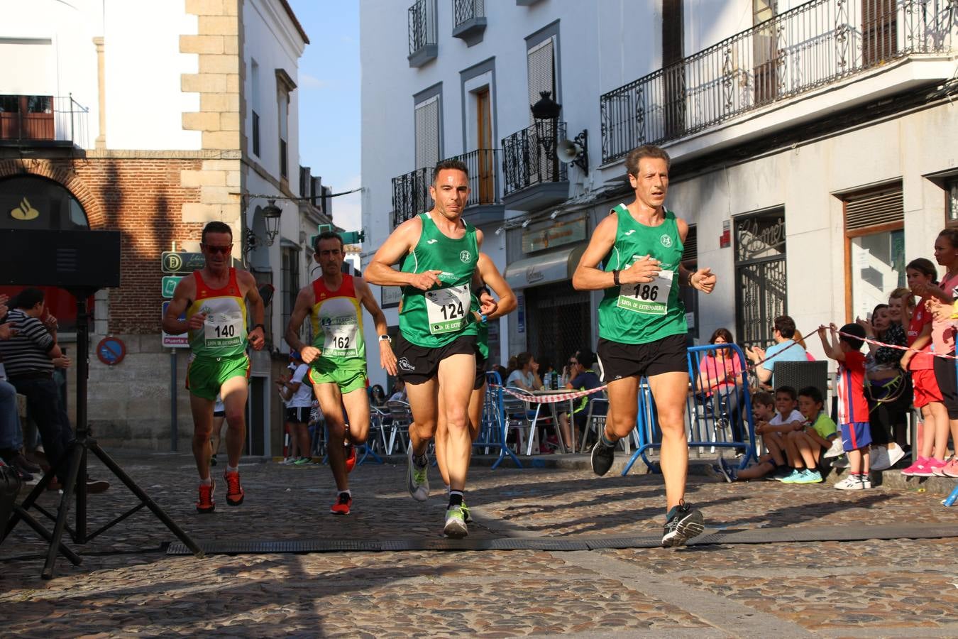 La Plaza de España de Jerez de los Caballeros acogió, ayer, la XXI Carrera Popular y VIII Caminata por la Salud y Solidaridad, organizada por la Concejalía de Juventud y Deportes del Ayuntamiento de Jerez con el apoyo del Programa de Dinamización Deportiva de la Mancomunidad Sierra Suroeste. Esta edición congregó a más de 250 participantes entre todas las categorías y se recaudaron 84 kilos de alimentos y 75 euros destinados a Cruz Roja en Jerez. La citada prueba se consagra, año tras año, como una de las citas deportivas ineludibles y más esperadas por los jerezanos y jerezanas. 