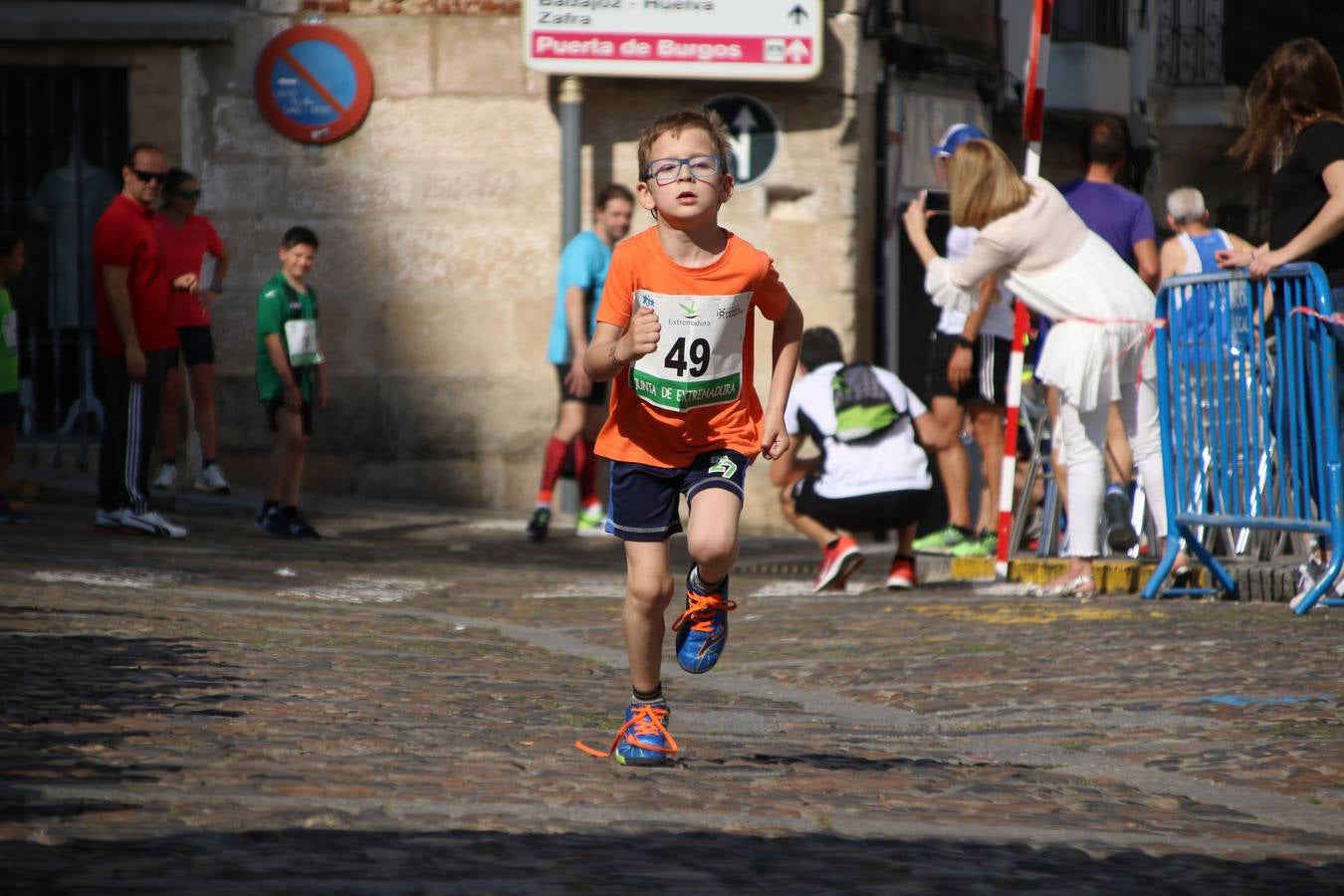 La Plaza de España de Jerez de los Caballeros acogió, ayer, la XXI Carrera Popular y VIII Caminata por la Salud y Solidaridad, organizada por la Concejalía de Juventud y Deportes del Ayuntamiento de Jerez con el apoyo del Programa de Dinamización Deportiva de la Mancomunidad Sierra Suroeste. Esta edición congregó a más de 250 participantes entre todas las categorías y se recaudaron 84 kilos de alimentos y 75 euros destinados a Cruz Roja en Jerez. La citada prueba se consagra, año tras año, como una de las citas deportivas ineludibles y más esperadas por los jerezanos y jerezanas. 