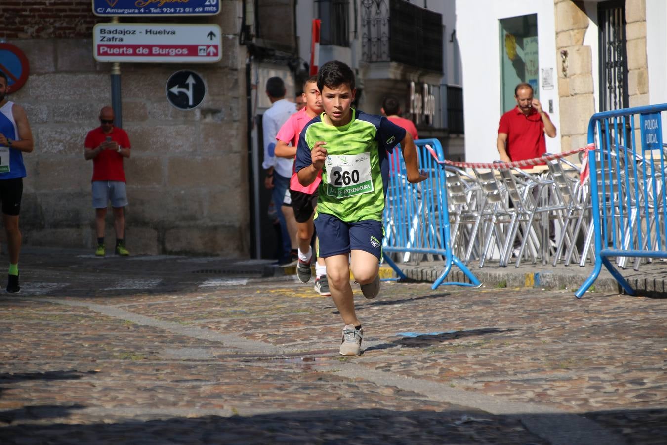 La Plaza de España de Jerez de los Caballeros acogió, ayer, la XXI Carrera Popular y VIII Caminata por la Salud y Solidaridad, organizada por la Concejalía de Juventud y Deportes del Ayuntamiento de Jerez con el apoyo del Programa de Dinamización Deportiva de la Mancomunidad Sierra Suroeste. Esta edición congregó a más de 250 participantes entre todas las categorías y se recaudaron 84 kilos de alimentos y 75 euros destinados a Cruz Roja en Jerez. La citada prueba se consagra, año tras año, como una de las citas deportivas ineludibles y más esperadas por los jerezanos y jerezanas. 