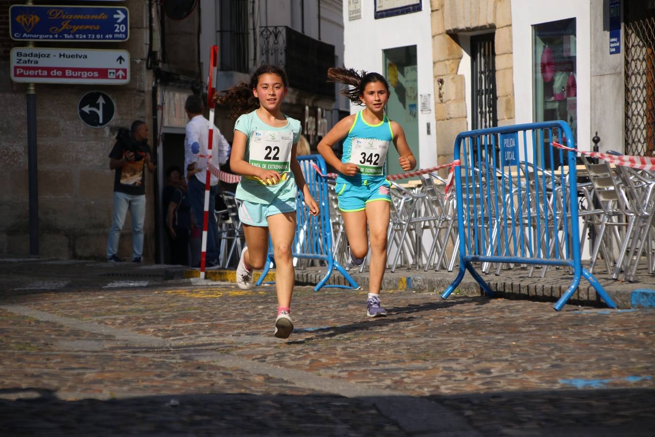 La Plaza de España de Jerez de los Caballeros acogió, ayer, la XXI Carrera Popular y VIII Caminata por la Salud y Solidaridad, organizada por la Concejalía de Juventud y Deportes del Ayuntamiento de Jerez con el apoyo del Programa de Dinamización Deportiva de la Mancomunidad Sierra Suroeste. Esta edición congregó a más de 250 participantes entre todas las categorías y se recaudaron 84 kilos de alimentos y 75 euros destinados a Cruz Roja en Jerez. La citada prueba se consagra, año tras año, como una de las citas deportivas ineludibles y más esperadas por los jerezanos y jerezanas. 