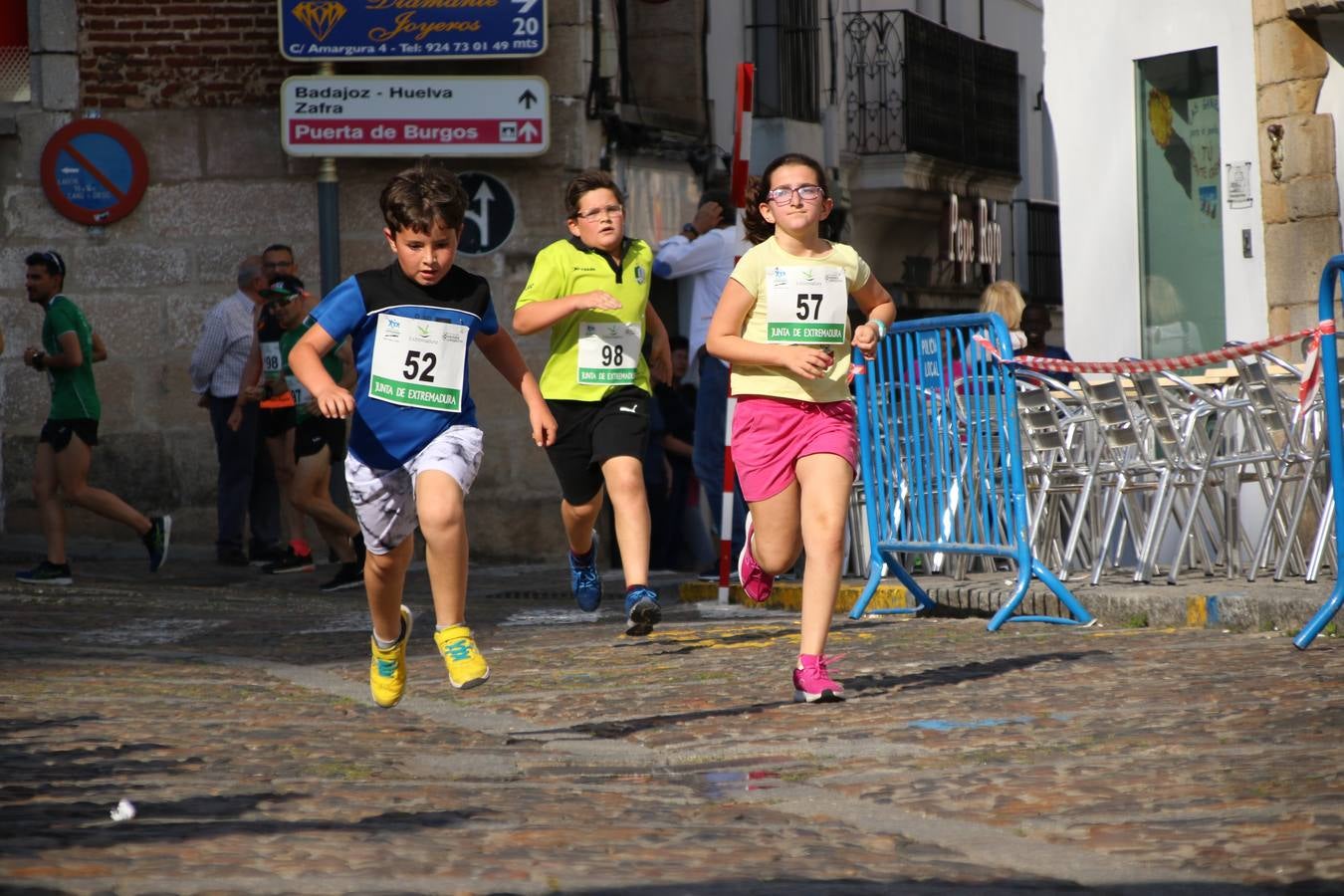 La Plaza de España de Jerez de los Caballeros acogió, ayer, la XXI Carrera Popular y VIII Caminata por la Salud y Solidaridad, organizada por la Concejalía de Juventud y Deportes del Ayuntamiento de Jerez con el apoyo del Programa de Dinamización Deportiva de la Mancomunidad Sierra Suroeste. Esta edición congregó a más de 250 participantes entre todas las categorías y se recaudaron 84 kilos de alimentos y 75 euros destinados a Cruz Roja en Jerez. La citada prueba se consagra, año tras año, como una de las citas deportivas ineludibles y más esperadas por los jerezanos y jerezanas. 