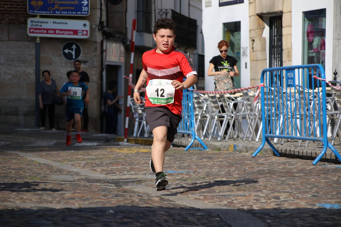 La Plaza de España de Jerez de los Caballeros acogió, ayer, la XXI Carrera Popular y VIII Caminata por la Salud y Solidaridad, organizada por la Concejalía de Juventud y Deportes del Ayuntamiento de Jerez con el apoyo del Programa de Dinamización Deportiva de la Mancomunidad Sierra Suroeste. Esta edición congregó a más de 250 participantes entre todas las categorías y se recaudaron 84 kilos de alimentos y 75 euros destinados a Cruz Roja en Jerez. La citada prueba se consagra, año tras año, como una de las citas deportivas ineludibles y más esperadas por los jerezanos y jerezanas. 