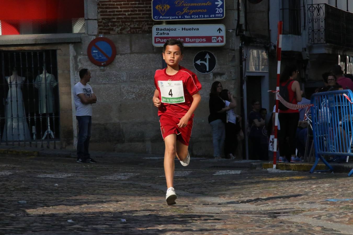 La Plaza de España de Jerez de los Caballeros acogió, ayer, la XXI Carrera Popular y VIII Caminata por la Salud y Solidaridad, organizada por la Concejalía de Juventud y Deportes del Ayuntamiento de Jerez con el apoyo del Programa de Dinamización Deportiva de la Mancomunidad Sierra Suroeste. Esta edición congregó a más de 250 participantes entre todas las categorías y se recaudaron 84 kilos de alimentos y 75 euros destinados a Cruz Roja en Jerez. La citada prueba se consagra, año tras año, como una de las citas deportivas ineludibles y más esperadas por los jerezanos y jerezanas. 