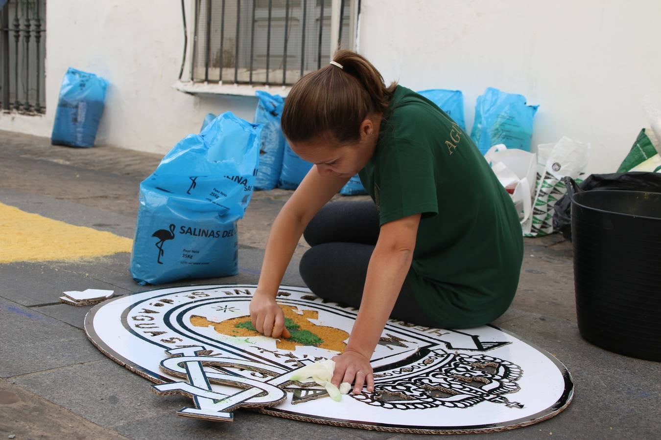 Las alfombras de sal embellecen y llenan de color, hoy, las calles de Jerez de los Caballeros con motivo de la festividad del Corpus Christi. Desde primera hora de la mañana, miembros de las cofradías y hermandades, Cáritas, grupos de catequesis, familias de los niños que han hecho este año la Primera Comunión, miembros de la Asociación de costaleros y costaleras de la Semana Santa jerezana, Ayuntamiento y vecinos han cubierto las principales calles del municipio con 6.250 kilos de sal teñida, plenas de color. A continuación, han disfrutado de una jornada de convivencia en la Casa de la Iglesia 'Cecilia de Arteaga'.