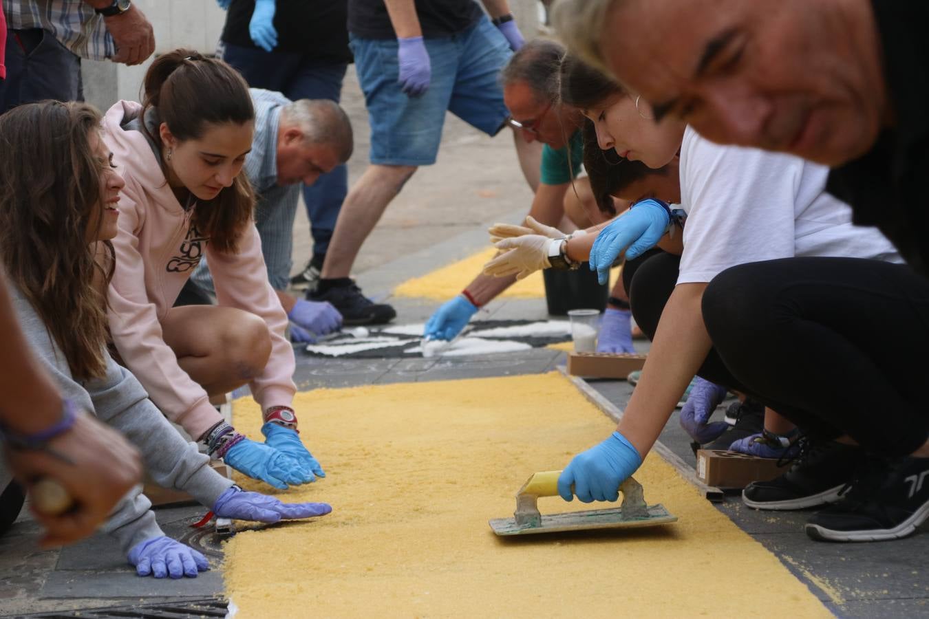 Las alfombras de sal embellecen y llenan de color, hoy, las calles de Jerez de los Caballeros con motivo de la festividad del Corpus Christi. Desde primera hora de la mañana, miembros de las cofradías y hermandades, Cáritas, grupos de catequesis, familias de los niños que han hecho este año la Primera Comunión, miembros de la Asociación de costaleros y costaleras de la Semana Santa jerezana, Ayuntamiento y vecinos han cubierto las principales calles del municipio con 6.250 kilos de sal teñida, plenas de color. A continuación, han disfrutado de una jornada de convivencia en la Casa de la Iglesia 'Cecilia de Arteaga'.