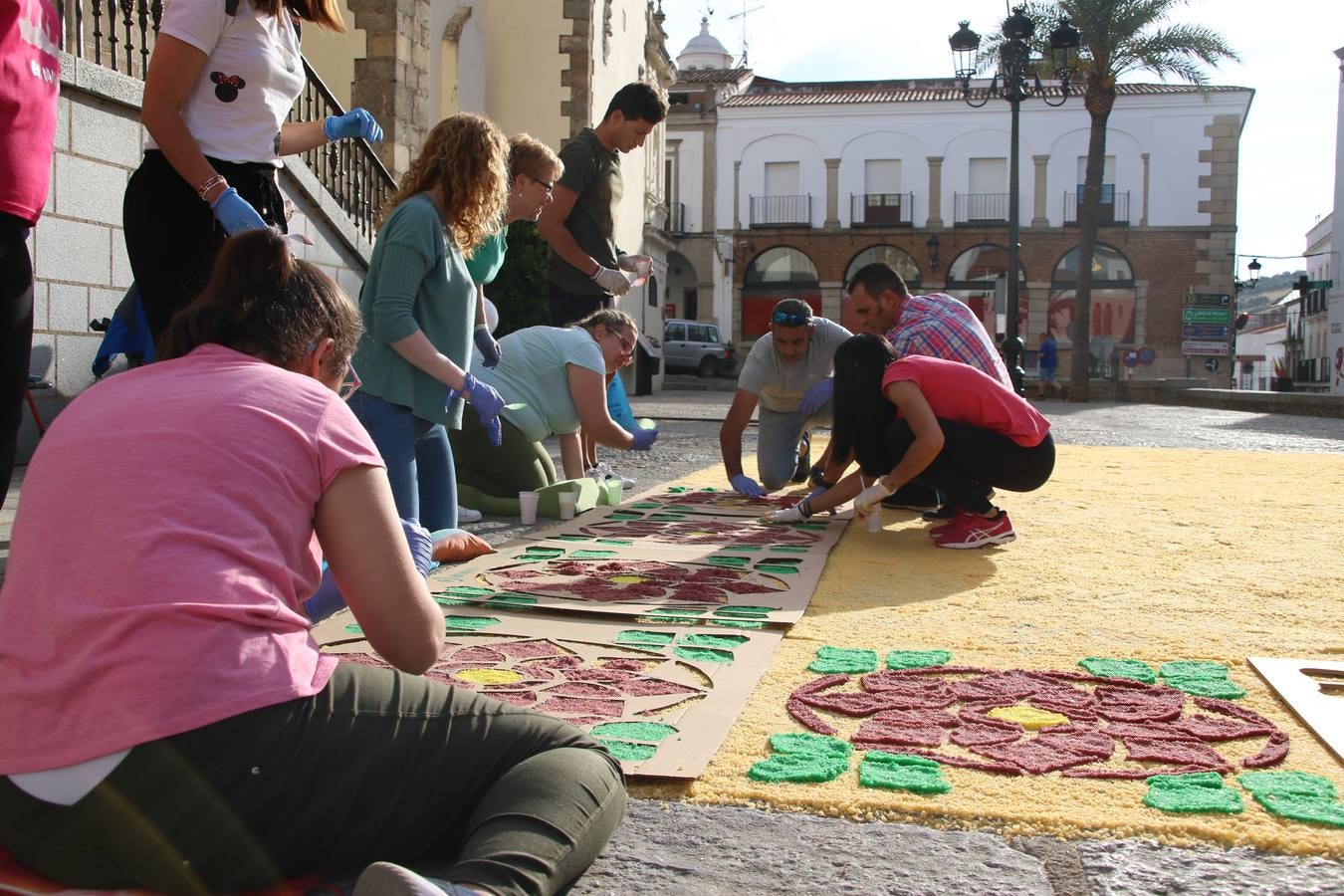 Las alfombras de sal embellecen y llenan de color, hoy, las calles de Jerez de los Caballeros con motivo de la festividad del Corpus Christi. Desde primera hora de la mañana, miembros de las cofradías y hermandades, Cáritas, grupos de catequesis, familias de los niños que han hecho este año la Primera Comunión, miembros de la Asociación de costaleros y costaleras de la Semana Santa jerezana, Ayuntamiento y vecinos han cubierto las principales calles del municipio con 6.250 kilos de sal teñida, plenas de color. A continuación, han disfrutado de una jornada de convivencia en la Casa de la Iglesia 'Cecilia de Arteaga'.