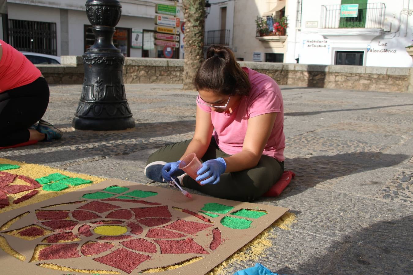 Las alfombras de sal embellecen y llenan de color, hoy, las calles de Jerez de los Caballeros con motivo de la festividad del Corpus Christi. Desde primera hora de la mañana, miembros de las cofradías y hermandades, Cáritas, grupos de catequesis, familias de los niños que han hecho este año la Primera Comunión, miembros de la Asociación de costaleros y costaleras de la Semana Santa jerezana, Ayuntamiento y vecinos han cubierto las principales calles del municipio con 6.250 kilos de sal teñida, plenas de color. A continuación, han disfrutado de una jornada de convivencia en la Casa de la Iglesia 'Cecilia de Arteaga'.