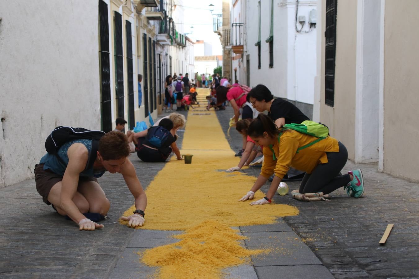 Las alfombras de sal embellecen y llenan de color, hoy, las calles de Jerez de los Caballeros con motivo de la festividad del Corpus Christi. Desde primera hora de la mañana, miembros de las cofradías y hermandades, Cáritas, grupos de catequesis, familias de los niños que han hecho este año la Primera Comunión, miembros de la Asociación de costaleros y costaleras de la Semana Santa jerezana, Ayuntamiento y vecinos han cubierto las principales calles del municipio con 6.250 kilos de sal teñida, plenas de color. A continuación, han disfrutado de una jornada de convivencia en la Casa de la Iglesia 'Cecilia de Arteaga'.