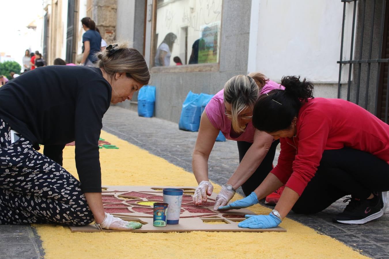 Las alfombras de sal embellecen y llenan de color, hoy, las calles de Jerez de los Caballeros con motivo de la festividad del Corpus Christi. Desde primera hora de la mañana, miembros de las cofradías y hermandades, Cáritas, grupos de catequesis, familias de los niños que han hecho este año la Primera Comunión, miembros de la Asociación de costaleros y costaleras de la Semana Santa jerezana, Ayuntamiento y vecinos han cubierto las principales calles del municipio con 6.250 kilos de sal teñida, plenas de color. A continuación, han disfrutado de una jornada de convivencia en la Casa de la Iglesia 'Cecilia de Arteaga'.