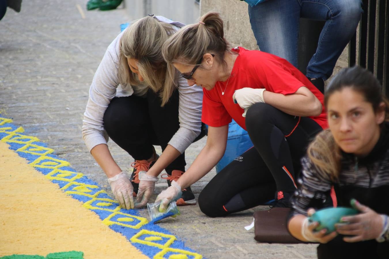 Las alfombras de sal embellecen y llenan de color, hoy, las calles de Jerez de los Caballeros con motivo de la festividad del Corpus Christi. Desde primera hora de la mañana, miembros de las cofradías y hermandades, Cáritas, grupos de catequesis, familias de los niños que han hecho este año la Primera Comunión, miembros de la Asociación de costaleros y costaleras de la Semana Santa jerezana, Ayuntamiento y vecinos han cubierto las principales calles del municipio con 6.250 kilos de sal teñida, plenas de color. A continuación, han disfrutado de una jornada de convivencia en la Casa de la Iglesia 'Cecilia de Arteaga'.