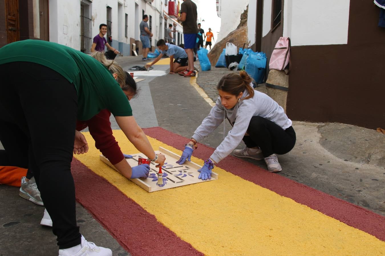 Las alfombras de sal embellecen y llenan de color, hoy, las calles de Jerez de los Caballeros con motivo de la festividad del Corpus Christi. Desde primera hora de la mañana, miembros de las cofradías y hermandades, Cáritas, grupos de catequesis, familias de los niños que han hecho este año la Primera Comunión, miembros de la Asociación de costaleros y costaleras de la Semana Santa jerezana, Ayuntamiento y vecinos han cubierto las principales calles del municipio con 6.250 kilos de sal teñida, plenas de color. A continuación, han disfrutado de una jornada de convivencia en la Casa de la Iglesia 'Cecilia de Arteaga'.