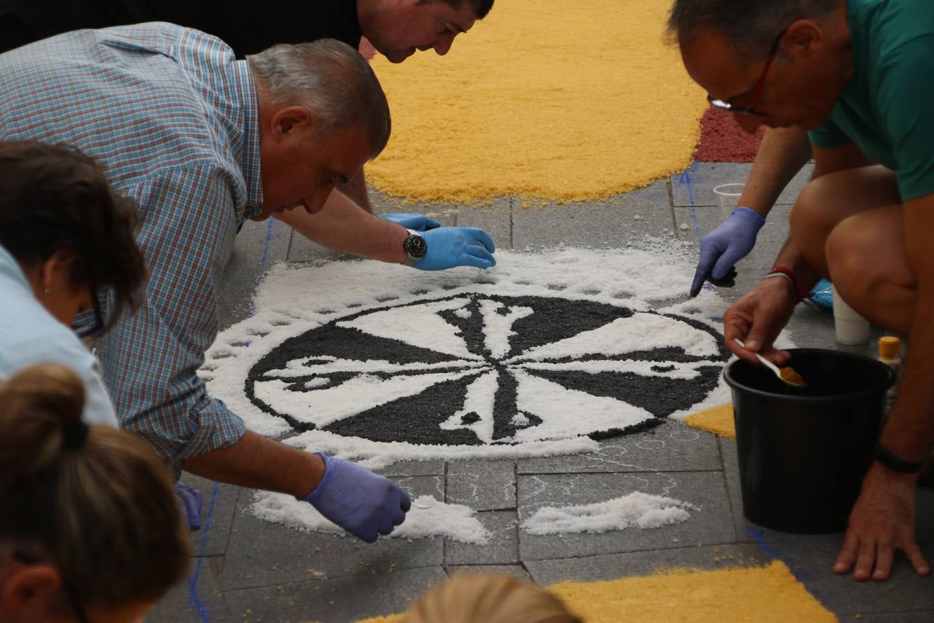 Las alfombras de sal embellecen y llenan de color, hoy, las calles de Jerez de los Caballeros con motivo de la festividad del Corpus Christi. Desde primera hora de la mañana, miembros de las cofradías y hermandades, Cáritas, grupos de catequesis, familias de los niños que han hecho este año la Primera Comunión, miembros de la Asociación de costaleros y costaleras de la Semana Santa jerezana, Ayuntamiento y vecinos han cubierto las principales calles del municipio con 6.250 kilos de sal teñida, plenas de color. A continuación, han disfrutado de una jornada de convivencia en la Casa de la Iglesia 'Cecilia de Arteaga'.