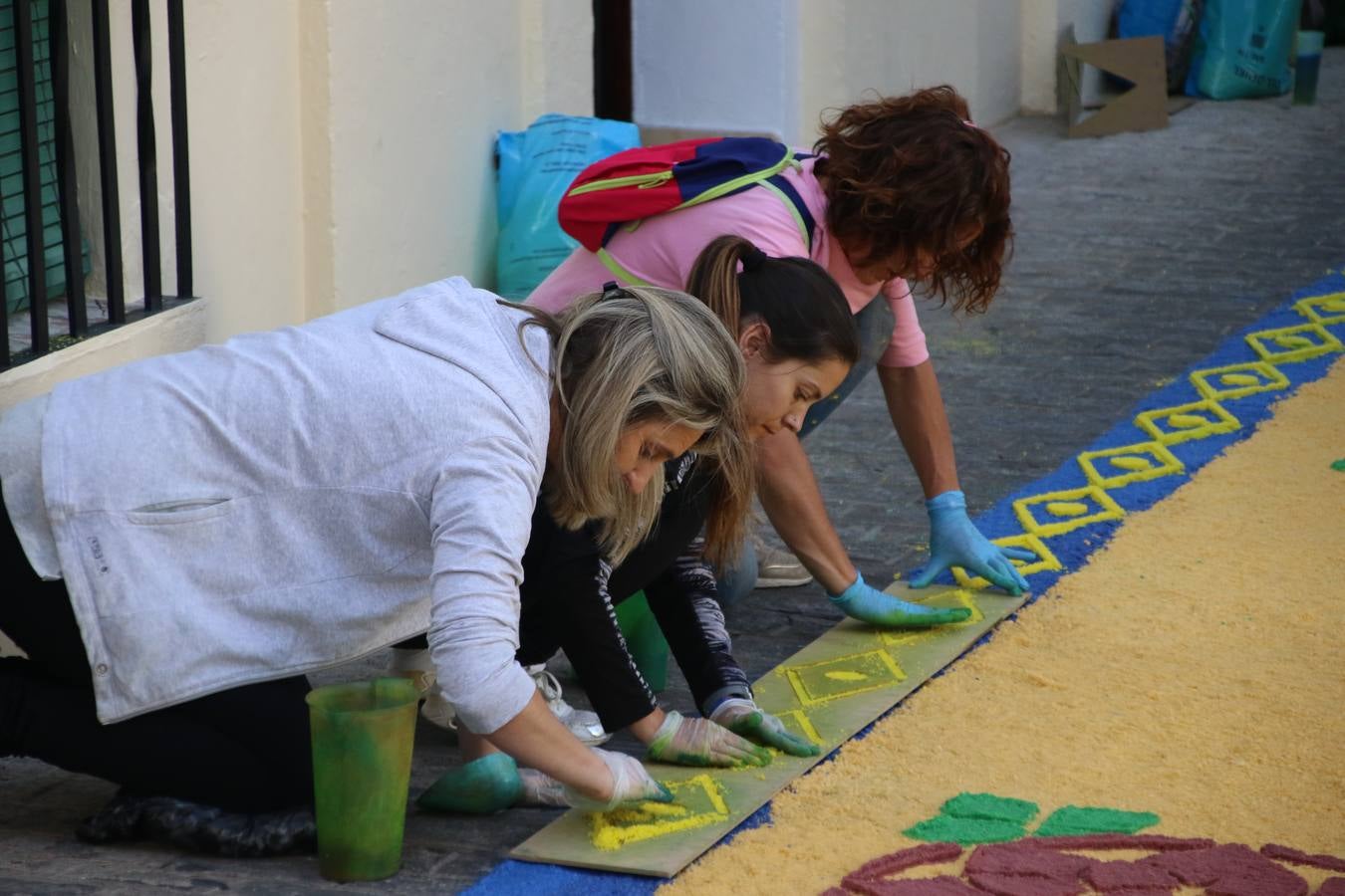 Las alfombras de sal embellecen y llenan de color, hoy, las calles de Jerez de los Caballeros con motivo de la festividad del Corpus Christi. Desde primera hora de la mañana, miembros de las cofradías y hermandades, Cáritas, grupos de catequesis, familias de los niños que han hecho este año la Primera Comunión, miembros de la Asociación de costaleros y costaleras de la Semana Santa jerezana, Ayuntamiento y vecinos han cubierto las principales calles del municipio con 6.250 kilos de sal teñida, plenas de color. A continuación, han disfrutado de una jornada de convivencia en la Casa de la Iglesia 'Cecilia de Arteaga'.