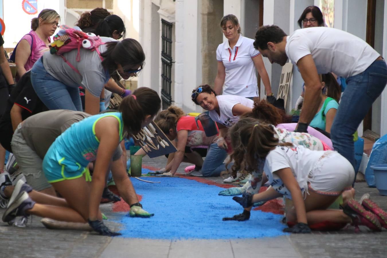 Las alfombras de sal embellecen y llenan de color, hoy, las calles de Jerez de los Caballeros con motivo de la festividad del Corpus Christi. Desde primera hora de la mañana, miembros de las cofradías y hermandades, Cáritas, grupos de catequesis, familias de los niños que han hecho este año la Primera Comunión, miembros de la Asociación de costaleros y costaleras de la Semana Santa jerezana, Ayuntamiento y vecinos han cubierto las principales calles del municipio con 6.250 kilos de sal teñida, plenas de color. A continuación, han disfrutado de una jornada de convivencia en la Casa de la Iglesia 'Cecilia de Arteaga'.