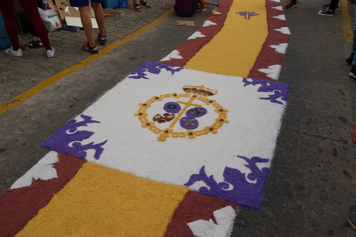Las alfombras de sal embellecen y llenan de color, hoy, las calles de Jerez de los Caballeros con motivo de la festividad del Corpus Christi. Desde primera hora de la mañana, miembros de las cofradías y hermandades, Cáritas, grupos de catequesis, familias de los niños que han hecho este año la Primera Comunión, miembros de la Asociación de costaleros y costaleras de la Semana Santa jerezana, Ayuntamiento y vecinos han cubierto las principales calles del municipio con 6.250 kilos de sal teñida, plenas de color. A continuación, han disfrutado de una jornada de convivencia en la Casa de la Iglesia 'Cecilia de Arteaga'.