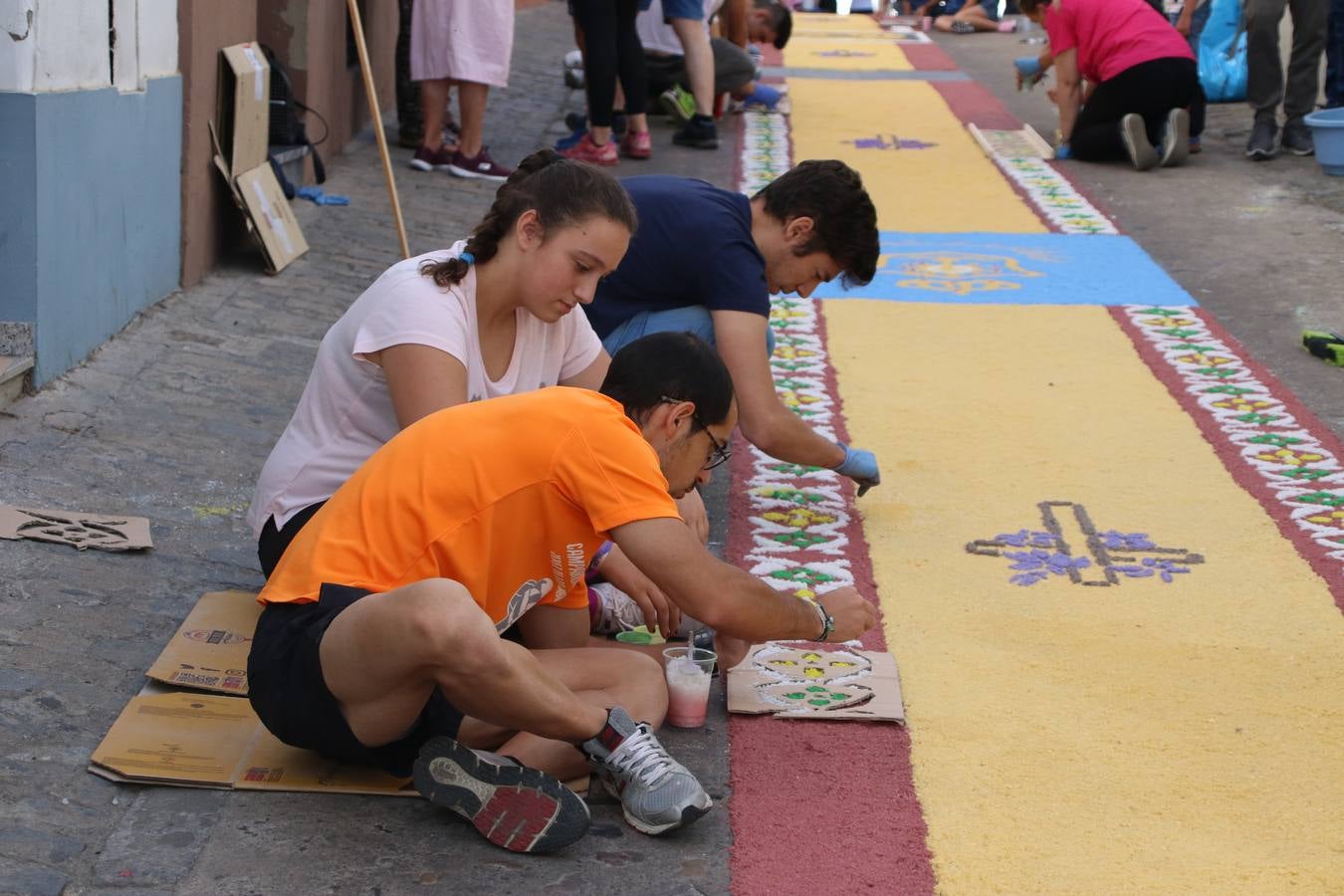 Las alfombras de sal embellecen y llenan de color, hoy, las calles de Jerez de los Caballeros con motivo de la festividad del Corpus Christi. Desde primera hora de la mañana, miembros de las cofradías y hermandades, Cáritas, grupos de catequesis, familias de los niños que han hecho este año la Primera Comunión, miembros de la Asociación de costaleros y costaleras de la Semana Santa jerezana, Ayuntamiento y vecinos han cubierto las principales calles del municipio con 6.250 kilos de sal teñida, plenas de color. A continuación, han disfrutado de una jornada de convivencia en la Casa de la Iglesia 'Cecilia de Arteaga'.