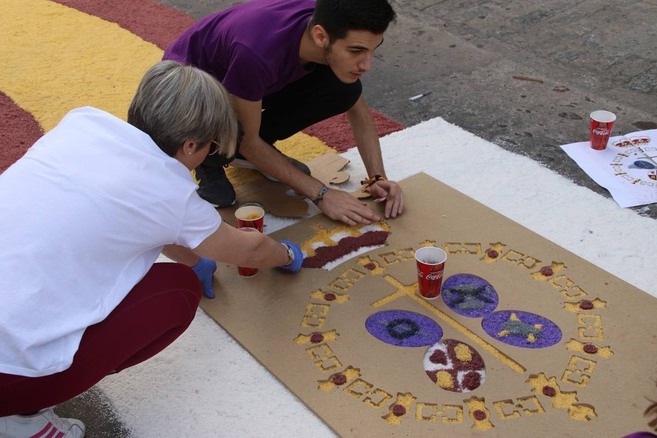 Las alfombras de sal embellecen y llenan de color, hoy, las calles de Jerez de los Caballeros con motivo de la festividad del Corpus Christi. Desde primera hora de la mañana, miembros de las cofradías y hermandades, Cáritas, grupos de catequesis, familias de los niños que han hecho este año la Primera Comunión, miembros de la Asociación de costaleros y costaleras de la Semana Santa jerezana, Ayuntamiento y vecinos han cubierto las principales calles del municipio con 6.250 kilos de sal teñida, plenas de color. A continuación, han disfrutado de una jornada de convivencia en la Casa de la Iglesia 'Cecilia de Arteaga'.