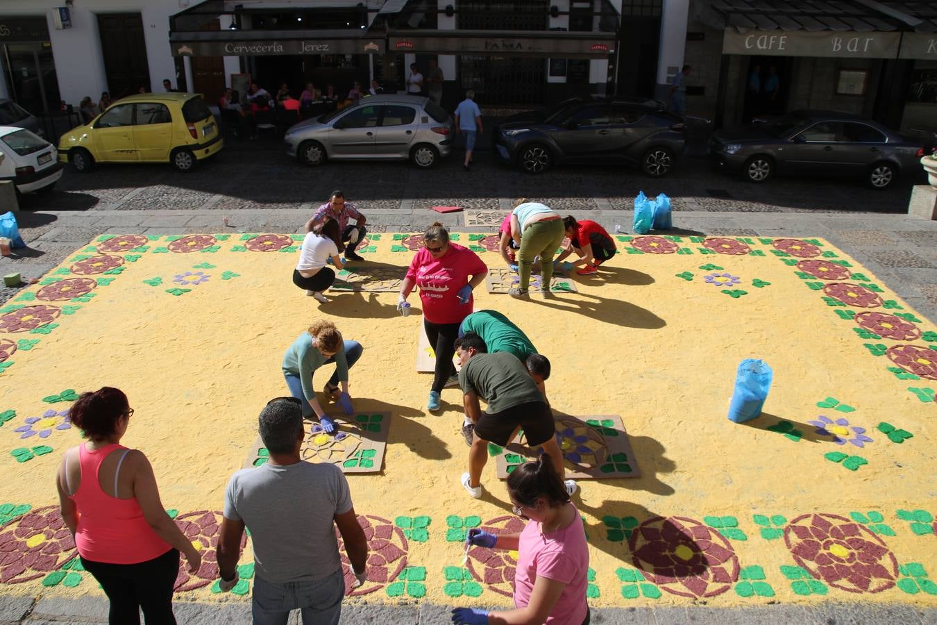 Las alfombras de sal embellecen y llenan de color, hoy, las calles de Jerez de los Caballeros con motivo de la festividad del Corpus Christi. Desde primera hora de la mañana, miembros de las cofradías y hermandades, Cáritas, grupos de catequesis, familias de los niños que han hecho este año la Primera Comunión, miembros de la Asociación de costaleros y costaleras de la Semana Santa jerezana, Ayuntamiento y vecinos han cubierto las principales calles del municipio con 6.250 kilos de sal teñida, plenas de color. A continuación, han disfrutado de una jornada de convivencia en la Casa de la Iglesia 'Cecilia de Arteaga'.