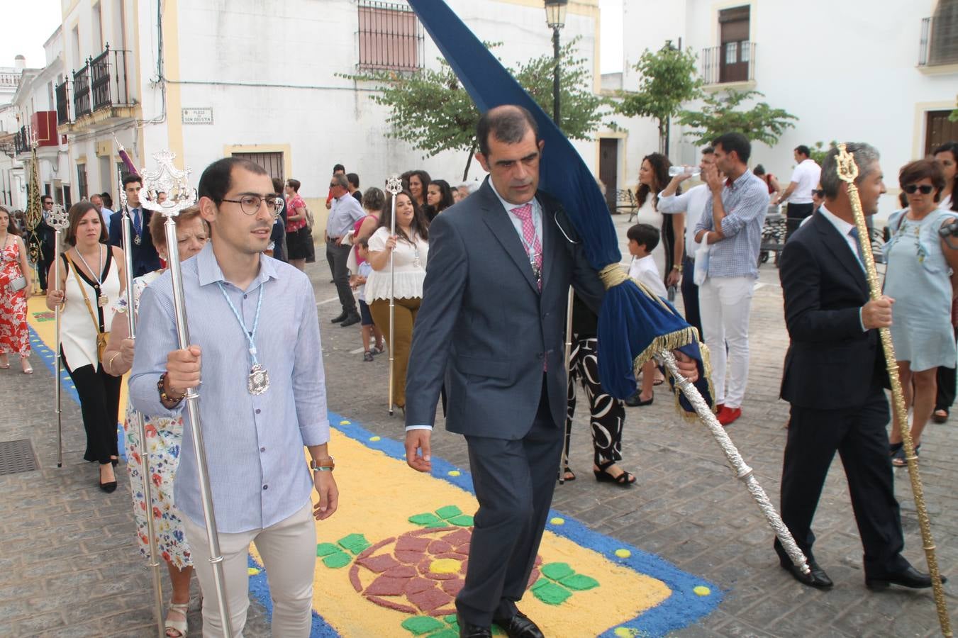 Jerez de los Caballeros celebró ayer la festividad del Corpus Christi en medio de un ambiente de solemnidad y convivencia del que fueron partícipes cientos de personas.La iglesia visigoda de Santa María de la Encarnación, llena de fieles, acogió la celebración de la Eucaristía que dió paso a la procesión acompañando la Santa Custodia en el magnífico templete de la iglesia de San Miguel, sobre las andas de la Virgen de Aguasantas y portada por costaleros y costaleras de la recién Asociación creada en esta ciudad. El párroco, Antonio María Rejano, destacó la significación de esta procesión, lamás grande, dijo, «porque Jesús sale a nuestras vidas, a nuestro encuentro y nosotros le acompañamos». Al término de la misa, incidió en el agradecimiento a todas las personas que han participado para hacer posible su desarrollo, trabajando desde la jornada del sábado en la elaboración de las preciosas alfombras de sal teñida de colores, que lucieron en las calles del centro de Jerez. El agradecimiento fue especial para los padres y madres de los niños y niñas que han hecho la Primera Comunión, para éstos mismos, también para catequistas, Cofradías y Hermandades, la Asociación del costaleros y costaleras de la Semana Santa de Jerez de los Caballeros, Ayuntamiento, Policía Local, grupos y personas de la parroquia.Autoridades civiles en representación del Ayuntamiento, Policía Local y Guardia Civil, acompañaron el desarrollo de la procesión junto a representantes de todas las cofradías y hermandades jerezanas y el protagonismo de los más de 80 niños y niñas que este año han celebrado su Primera Comunión.  A lo largo de todo el recorrido se instalaron distintos altares, también con la colaboración de vecinos y centros como la Residencia de Mayores Hernando de Soto. Los magníficos sones de la Agrupación Musical 'Nuestro Padre Jesús Nazareno' coronaron esta hermosa procesión.