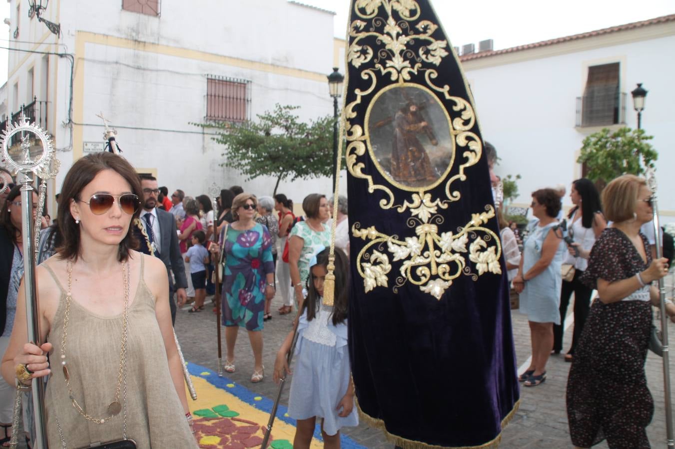 Jerez de los Caballeros celebró ayer la festividad del Corpus Christi en medio de un ambiente de solemnidad y convivencia del que fueron partícipes cientos de personas.La iglesia visigoda de Santa María de la Encarnación, llena de fieles, acogió la celebración de la Eucaristía que dió paso a la procesión acompañando la Santa Custodia en el magnífico templete de la iglesia de San Miguel, sobre las andas de la Virgen de Aguasantas y portada por costaleros y costaleras de la recién Asociación creada en esta ciudad. El párroco, Antonio María Rejano, destacó la significación de esta procesión, lamás grande, dijo, «porque Jesús sale a nuestras vidas, a nuestro encuentro y nosotros le acompañamos». Al término de la misa, incidió en el agradecimiento a todas las personas que han participado para hacer posible su desarrollo, trabajando desde la jornada del sábado en la elaboración de las preciosas alfombras de sal teñida de colores, que lucieron en las calles del centro de Jerez. El agradecimiento fue especial para los padres y madres de los niños y niñas que han hecho la Primera Comunión, para éstos mismos, también para catequistas, Cofradías y Hermandades, la Asociación del costaleros y costaleras de la Semana Santa de Jerez de los Caballeros, Ayuntamiento, Policía Local, grupos y personas de la parroquia.Autoridades civiles en representación del Ayuntamiento, Policía Local y Guardia Civil, acompañaron el desarrollo de la procesión junto a representantes de todas las cofradías y hermandades jerezanas y el protagonismo de los más de 80 niños y niñas que este año han celebrado su Primera Comunión.  A lo largo de todo el recorrido se instalaron distintos altares, también con la colaboración de vecinos y centros como la Residencia de Mayores Hernando de Soto. Los magníficos sones de la Agrupación Musical 'Nuestro Padre Jesús Nazareno' coronaron esta hermosa procesión.