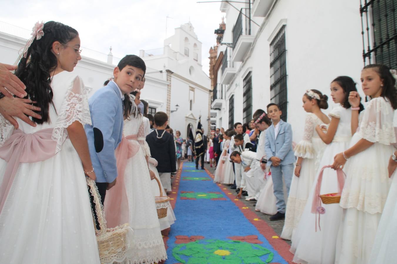 Jerez de los Caballeros celebró ayer la festividad del Corpus Christi en medio de un ambiente de solemnidad y convivencia del que fueron partícipes cientos de personas.La iglesia visigoda de Santa María de la Encarnación, llena de fieles, acogió la celebración de la Eucaristía que dió paso a la procesión acompañando la Santa Custodia en el magnífico templete de la iglesia de San Miguel, sobre las andas de la Virgen de Aguasantas y portada por costaleros y costaleras de la recién Asociación creada en esta ciudad. El párroco, Antonio María Rejano, destacó la significación de esta procesión, lamás grande, dijo, «porque Jesús sale a nuestras vidas, a nuestro encuentro y nosotros le acompañamos». Al término de la misa, incidió en el agradecimiento a todas las personas que han participado para hacer posible su desarrollo, trabajando desde la jornada del sábado en la elaboración de las preciosas alfombras de sal teñida de colores, que lucieron en las calles del centro de Jerez. El agradecimiento fue especial para los padres y madres de los niños y niñas que han hecho la Primera Comunión, para éstos mismos, también para catequistas, Cofradías y Hermandades, la Asociación del costaleros y costaleras de la Semana Santa de Jerez de los Caballeros, Ayuntamiento, Policía Local, grupos y personas de la parroquia.Autoridades civiles en representación del Ayuntamiento, Policía Local y Guardia Civil, acompañaron el desarrollo de la procesión junto a representantes de todas las cofradías y hermandades jerezanas y el protagonismo de los más de 80 niños y niñas que este año han celebrado su Primera Comunión.  A lo largo de todo el recorrido se instalaron distintos altares, también con la colaboración de vecinos y centros como la Residencia de Mayores Hernando de Soto. Los magníficos sones de la Agrupación Musical 'Nuestro Padre Jesús Nazareno' coronaron esta hermosa procesión.
