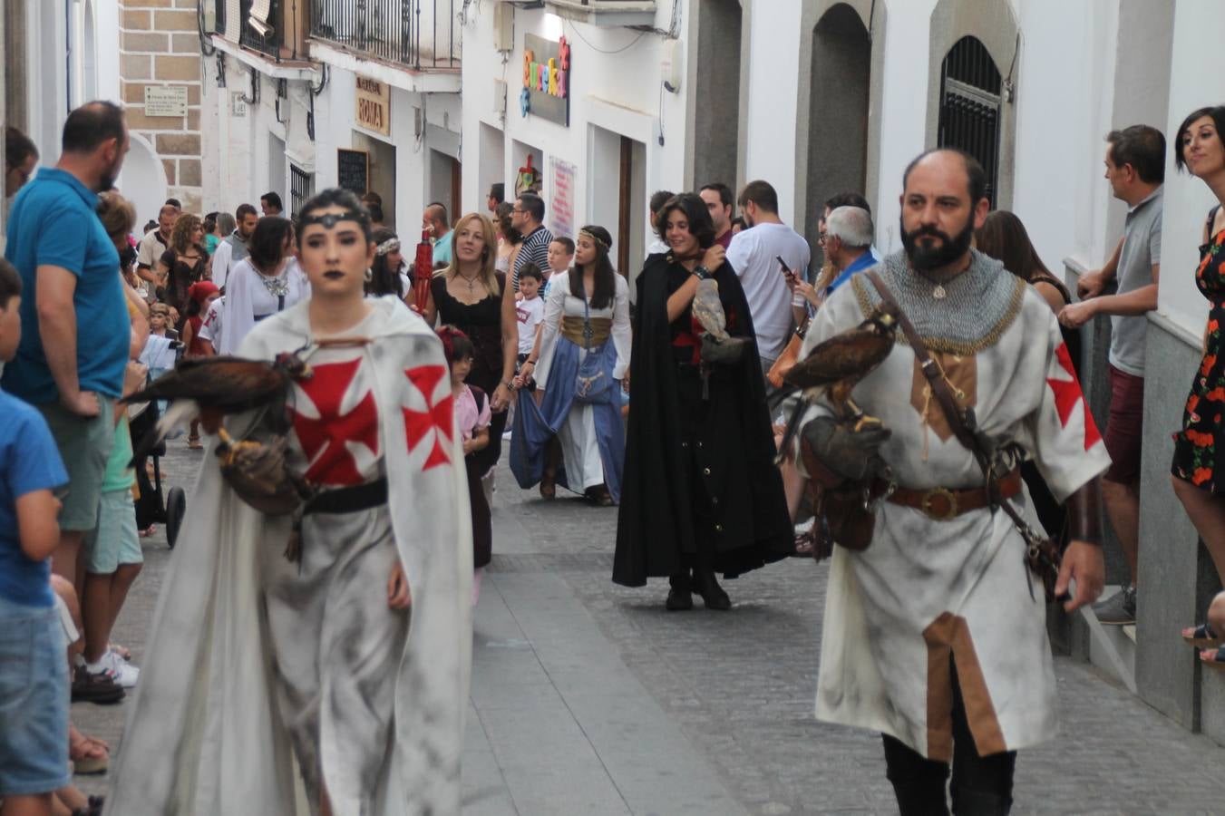 La participación popular fue nuevo protagonista del desfile teatralizado que anoche inauguró el grueso de la programación del XVI Festival Templario, invitando a propios y visitantes a revivir un pasado de leyenda, concretamente el siglo en el que La Orden del Temple marcó la vida de esta ciudad, en la que tuvo una de sus principales Encomiendas, siendo además el último reducto de Los Templarios en los reinos de España.La Asociación juvenil y cultural 'La Trouppe' estuvo al frente de la coordinación de dicho desfile que llenó de ambiente y animación las calles y plazas del centro histórico de Jerez de los Caballeros, llenas de público y engalanadas para la ocasión con pendones con la cruz templaria y otros elementos referentes a la cultura árabe que dejó su impronta en aquella época. Destacó la participación de más de 60 niñas que pusieron alegría con sus bailes a este pasacalle, junto a personajes fantásticos en zancos, la melodía de la Asociación Musical de Jerez de los Caballeros y la participación de asociaciones, como la del Belén 'Santa Ángela', Euexia Rural, además de los caballeros del campamento medieval a cargo de Cabalbur y de manera especial, la implicación de numerosos vecinos de todas las edades que desfilaron ataviados con indumentaria de la época dando vida a esta celebración.