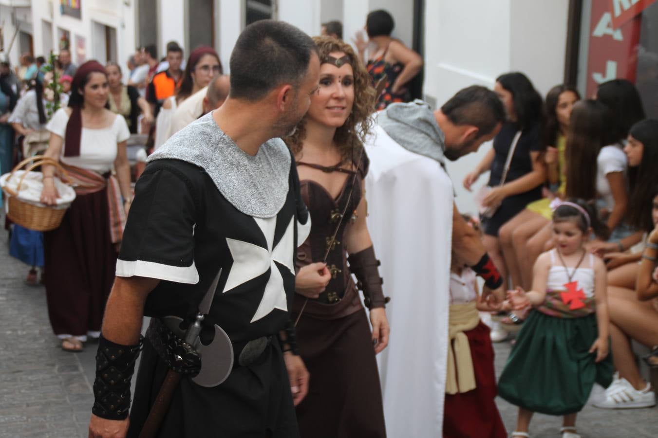 La participación popular fue nuevo protagonista del desfile teatralizado que anoche inauguró el grueso de la programación del XVI Festival Templario, invitando a propios y visitantes a revivir un pasado de leyenda, concretamente el siglo en el que La Orden del Temple marcó la vida de esta ciudad, en la que tuvo una de sus principales Encomiendas, siendo además el último reducto de Los Templarios en los reinos de España.La Asociación juvenil y cultural 'La Trouppe' estuvo al frente de la coordinación de dicho desfile que llenó de ambiente y animación las calles y plazas del centro histórico de Jerez de los Caballeros, llenas de público y engalanadas para la ocasión con pendones con la cruz templaria y otros elementos referentes a la cultura árabe que dejó su impronta en aquella época. Destacó la participación de más de 60 niñas que pusieron alegría con sus bailes a este pasacalle, junto a personajes fantásticos en zancos, la melodía de la Asociación Musical de Jerez de los Caballeros y la participación de asociaciones, como la del Belén 'Santa Ángela', Euexia Rural, además de los caballeros del campamento medieval a cargo de Cabalbur y de manera especial, la implicación de numerosos vecinos de todas las edades que desfilaron ataviados con indumentaria de la época dando vida a esta celebración.