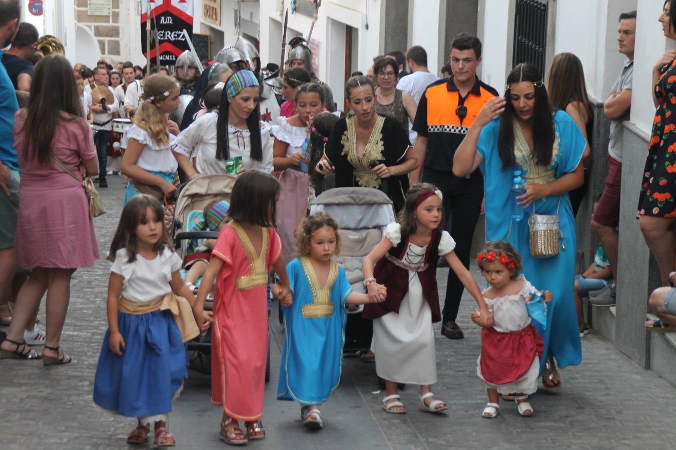 La participación popular fue nuevo protagonista del desfile teatralizado que anoche inauguró el grueso de la programación del XVI Festival Templario, invitando a propios y visitantes a revivir un pasado de leyenda, concretamente el siglo en el que La Orden del Temple marcó la vida de esta ciudad, en la que tuvo una de sus principales Encomiendas, siendo además el último reducto de Los Templarios en los reinos de España.La Asociación juvenil y cultural 'La Trouppe' estuvo al frente de la coordinación de dicho desfile que llenó de ambiente y animación las calles y plazas del centro histórico de Jerez de los Caballeros, llenas de público y engalanadas para la ocasión con pendones con la cruz templaria y otros elementos referentes a la cultura árabe que dejó su impronta en aquella época. Destacó la participación de más de 60 niñas que pusieron alegría con sus bailes a este pasacalle, junto a personajes fantásticos en zancos, la melodía de la Asociación Musical de Jerez de los Caballeros y la participación de asociaciones, como la del Belén 'Santa Ángela', Euexia Rural, además de los caballeros del campamento medieval a cargo de Cabalbur y de manera especial, la implicación de numerosos vecinos de todas las edades que desfilaron ataviados con indumentaria de la época dando vida a esta celebración.