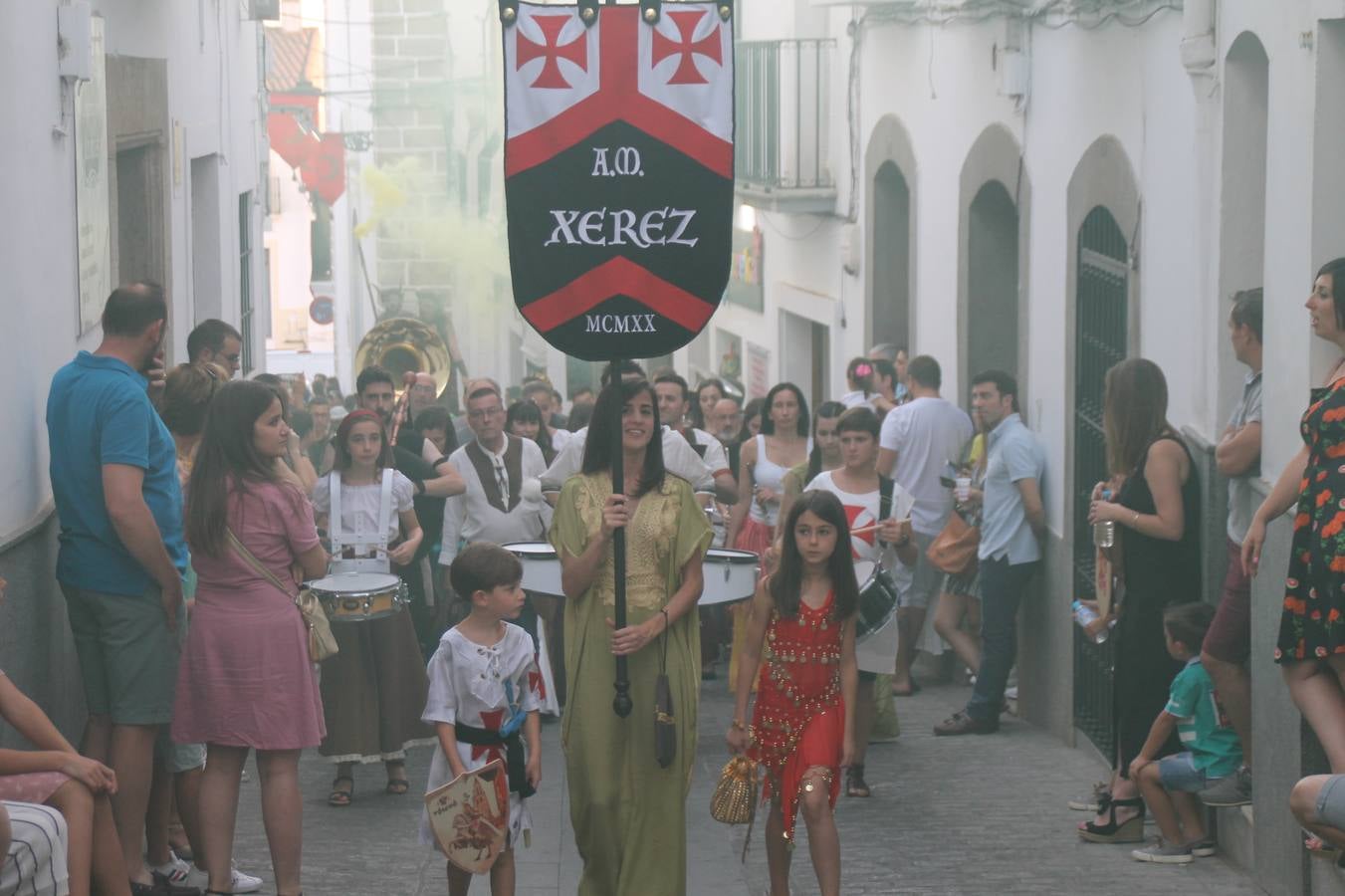La participación popular fue nuevo protagonista del desfile teatralizado que anoche inauguró el grueso de la programación del XVI Festival Templario, invitando a propios y visitantes a revivir un pasado de leyenda, concretamente el siglo en el que La Orden del Temple marcó la vida de esta ciudad, en la que tuvo una de sus principales Encomiendas, siendo además el último reducto de Los Templarios en los reinos de España.La Asociación juvenil y cultural 'La Trouppe' estuvo al frente de la coordinación de dicho desfile que llenó de ambiente y animación las calles y plazas del centro histórico de Jerez de los Caballeros, llenas de público y engalanadas para la ocasión con pendones con la cruz templaria y otros elementos referentes a la cultura árabe que dejó su impronta en aquella época. Destacó la participación de más de 60 niñas que pusieron alegría con sus bailes a este pasacalle, junto a personajes fantásticos en zancos, la melodía de la Asociación Musical de Jerez de los Caballeros y la participación de asociaciones, como la del Belén 'Santa Ángela', Euexia Rural, además de los caballeros del campamento medieval a cargo de Cabalbur y de manera especial, la implicación de numerosos vecinos de todas las edades que desfilaron ataviados con indumentaria de la época dando vida a esta celebración.